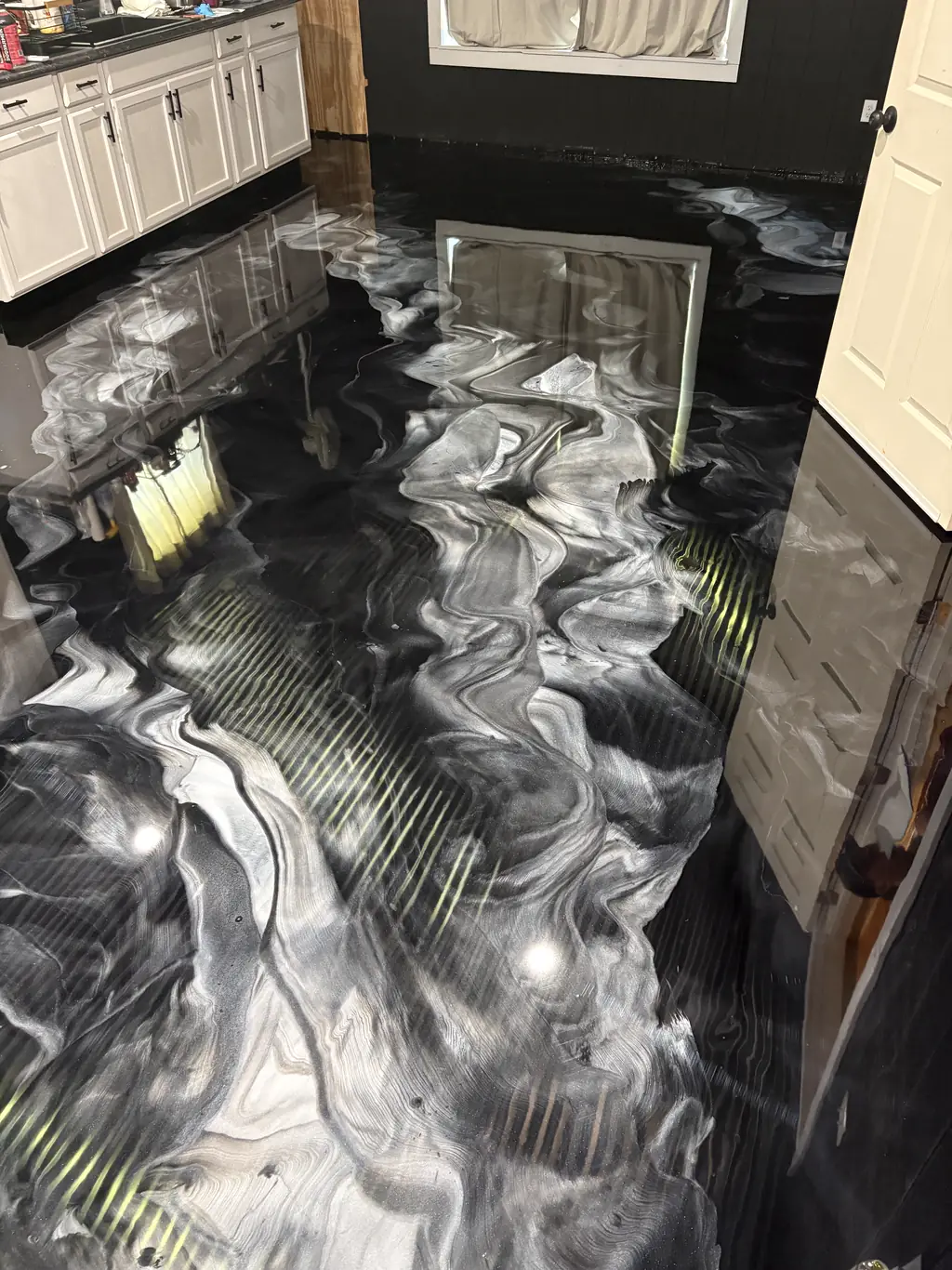 Close view of swirled black and silver metallic epoxy floor veining in a kitchen